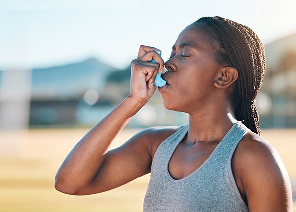 Woman uses asthma inhaler