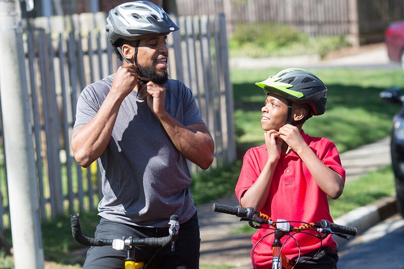 Father and son buckle bike helmets
