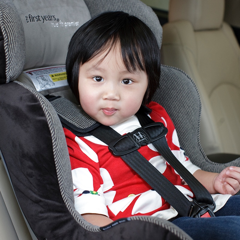 Child sits in a properly fitted car seat