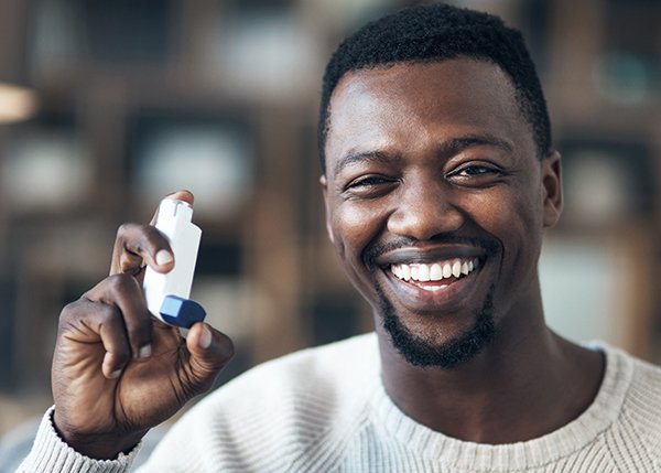 man holding an asthma inhaler