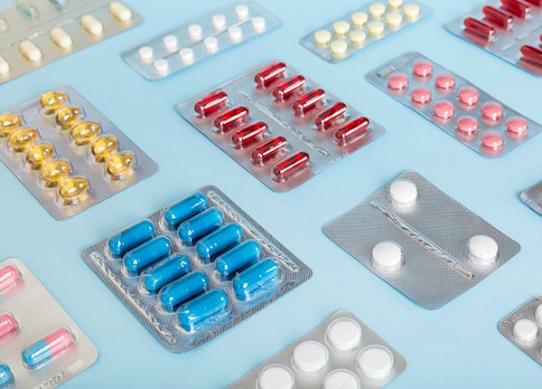 Various pills in packaging placed on a table top